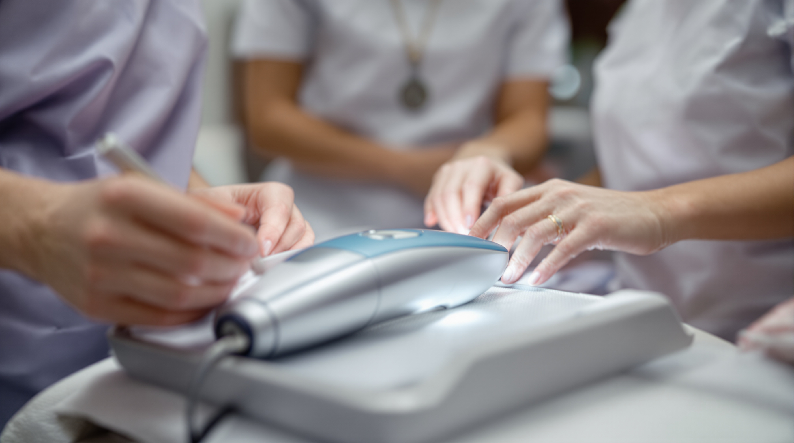 White body-contouring handpiece resting on a folded towel in a serene treatment room
